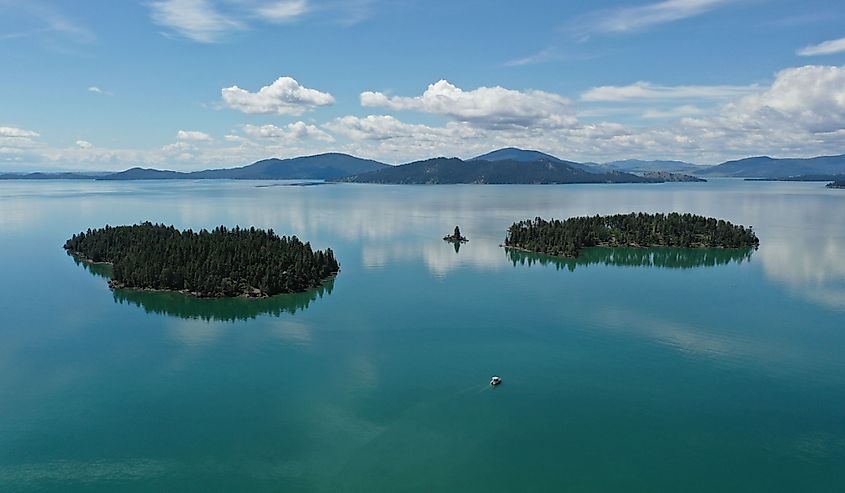 Aerial view of islands and distant mountains in Flathead Lake, Montana on calm summer morning.